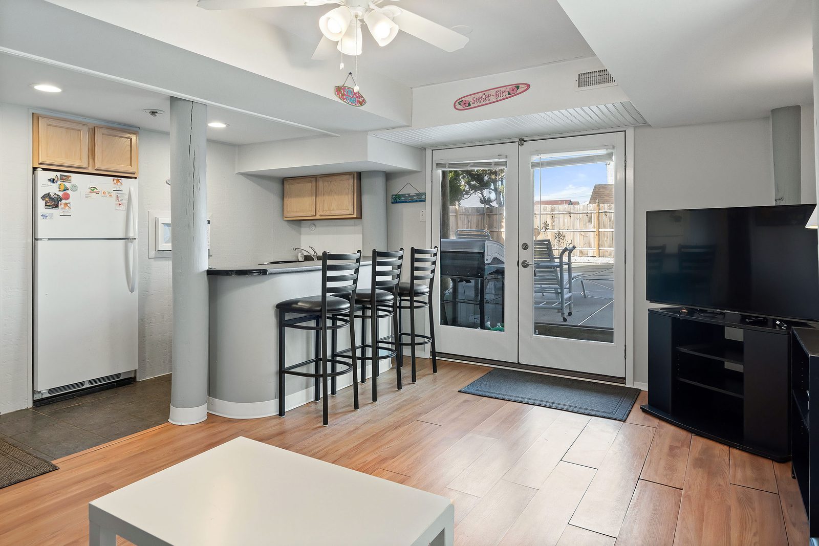 Ground floor family room with wet bar, seating, and doors to the pool patio