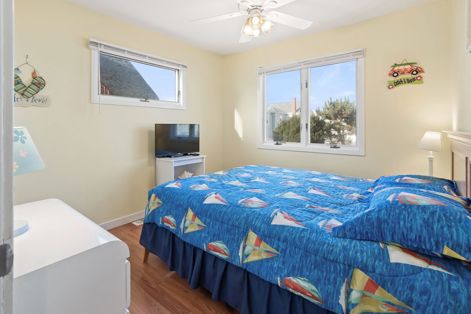 Queen bedroom with sailboat bedding and TV
