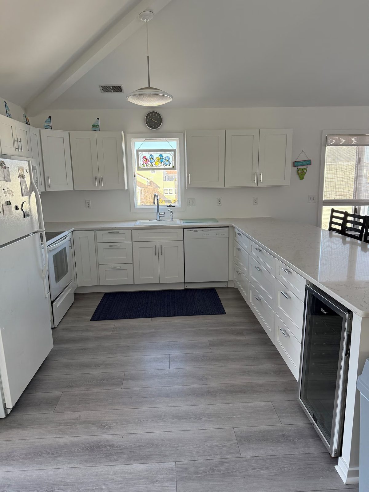 Kitchen with white cabinets, built-in oven, and window view